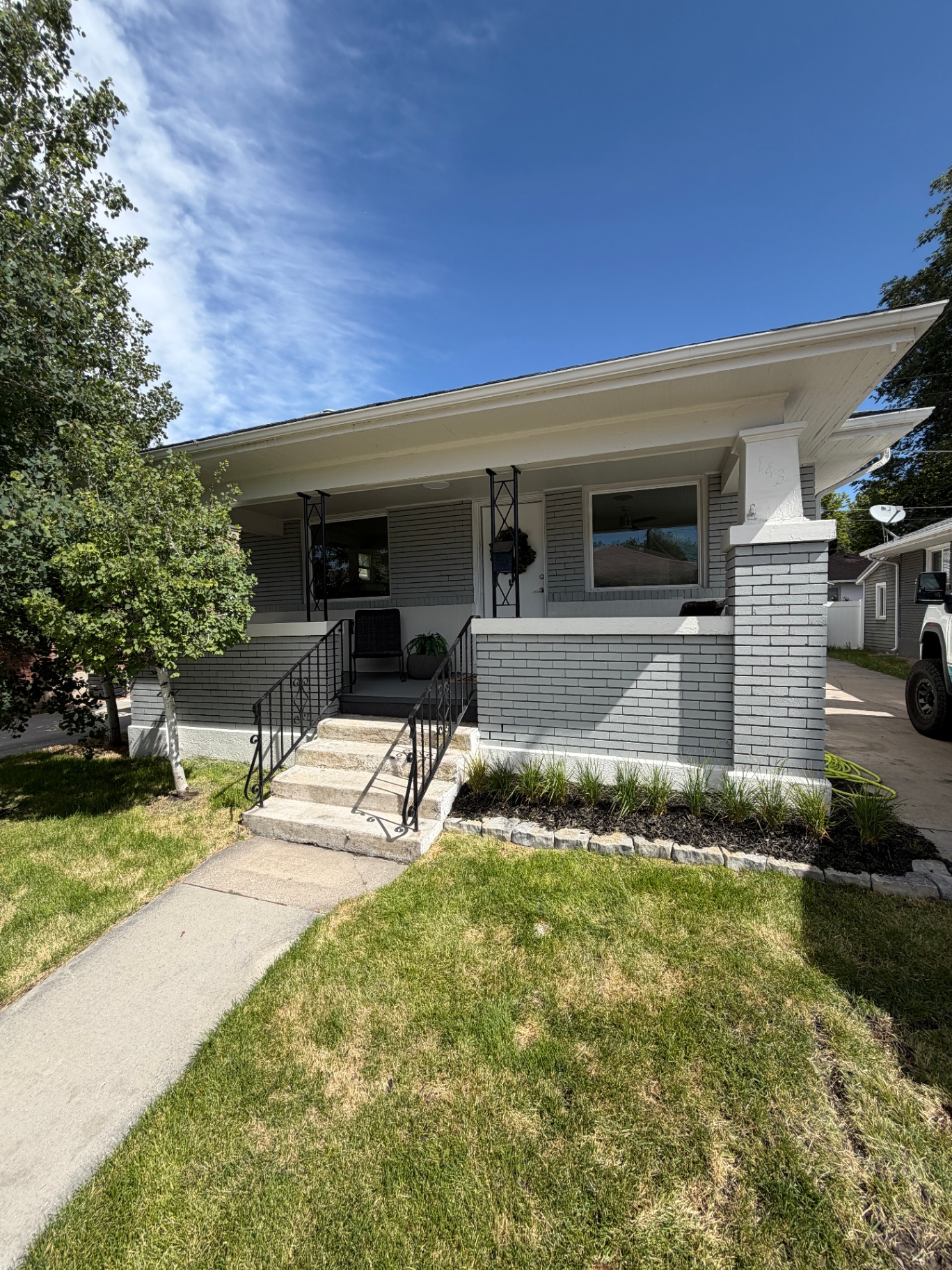 Exterior of 143 E Hampton Ave, a rebuilt gray brick bungalow
